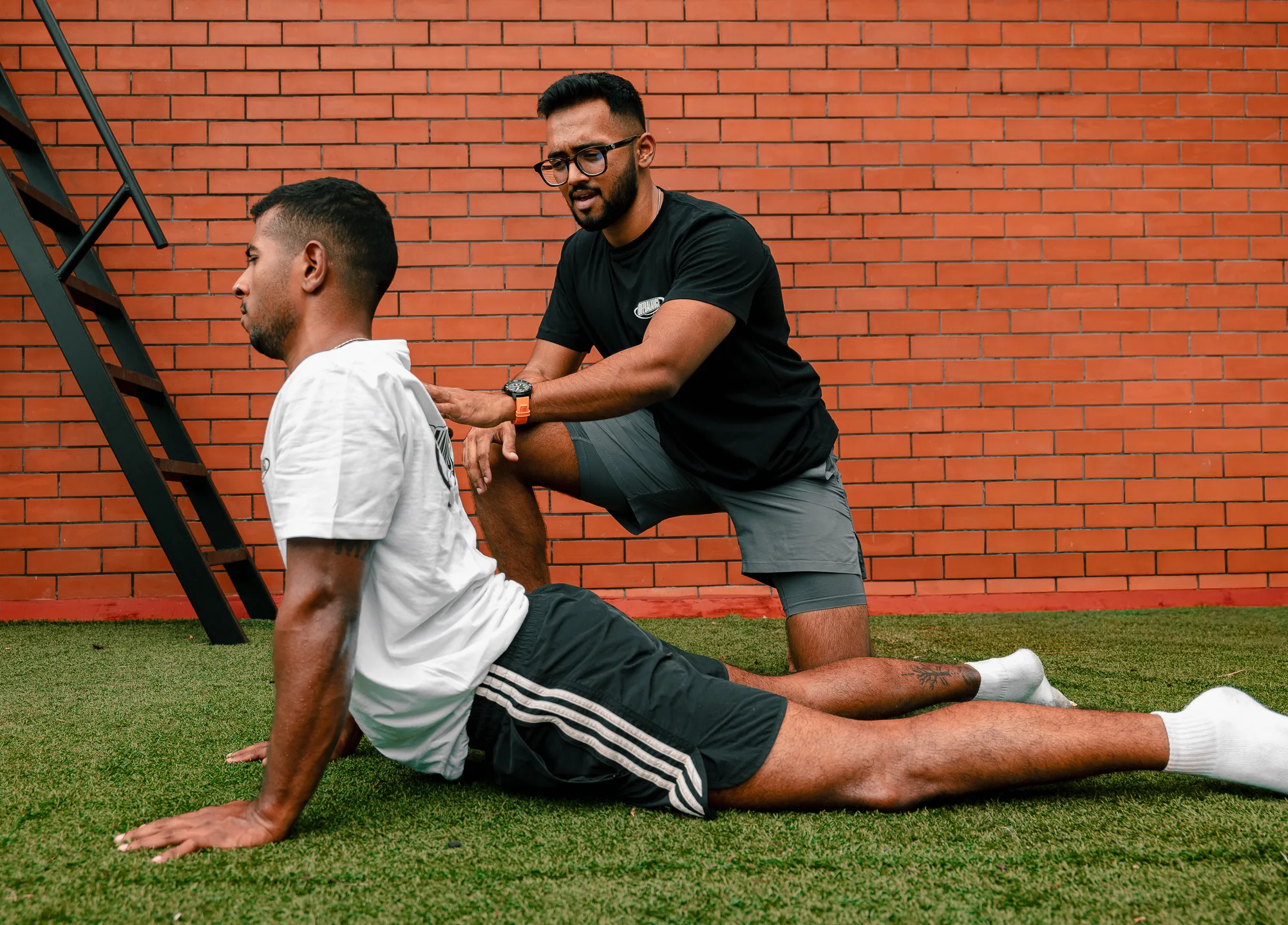 Achuthan coaching CJ through a barbell lift in the Off Balance training space